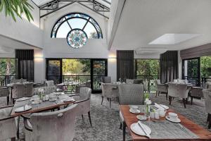 a dining room with tables and chairs and a window at Protea Hotel by Marriott Midrand in Midrand