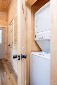 a laundry room with a washer and dryer in a tiny house at Cloudchaser Cabin, Private, New Cabin, 2 Kings, Cozy, Modern, Hot Tub, View, Theater in Sevierville