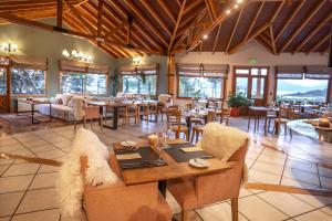Hotel Los Ñires في أوشوايا: غرفة طعام مع طاولات وكراسي في مطعم