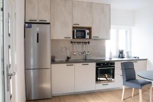 a kitchen with a stainless steel refrigerator and a table at Villa Koraljka in Vodice