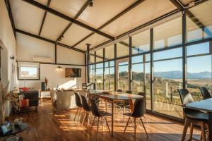 Habitación con mesa, sillas y ventanas grandes. en Tu Apart en Bariloche 5 en Dina Huapi