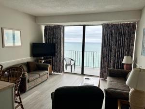 a living room with a couch and a large window at ROYAL GARDEN RESORT 1510 condo in Myrtle Beach
