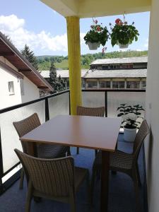 a table and chairs on a balcony with a train at Apartman Mušinbegović in Visoko