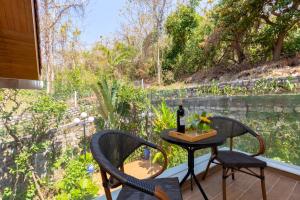 a patio with two chairs and a table with a bottle of wine at Cosa villages in Vung Tau
