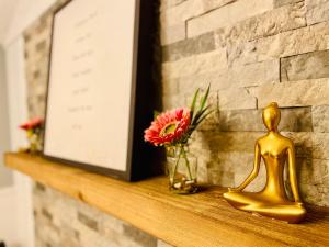 a gold figurine sitting on a shelf with flowers at Contemporary Magic Mountain Chalet Close to Skiing, Hiking, Fun in Londonderry