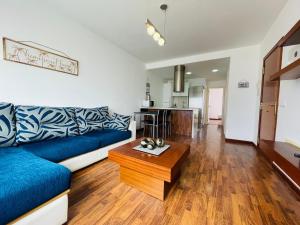 salon z niebieską kanapą i drewnianym stołem w obiekcie Casa One Love El Cotillo w mieście Cotillo