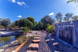 einen Garten mit einem Steinweg neben einem Teich in der Unterkunft Villa - Algarve, Portugal, 4 Bed ensuite, private pool, lake and beautiful gardens in Almancil