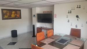 einen Konferenzraum mit einem Tisch und einem TV in der Unterkunft Lindo apto al lado del parque del ingenio in Cali