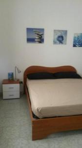 un letto in una camera da letto con immagini appese al muro di Villa Papi a Marina di Lizzano