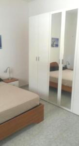 una camera con specchio e un letto in una stanza di Villa Papi a Marina di Lizzano