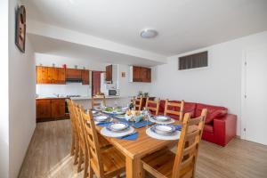 mesa de comedor con sillas y sofá rojo en Casa soleggiata sull'altopiano, en Clusone