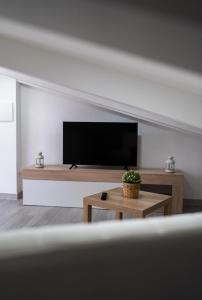 uma sala de estar com uma televisão de ecrã plano na parede em Lotfnazarewaves na Nazaré