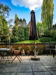 un ombrellone e una sedia su un patio di STUDIO A LOUER RÉSIDENCE LA SOURCE a Bruxelles