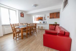uma sala de estar com uma mesa e um sofá vermelho em Casa soleggiata sull'altopiano em Clusone