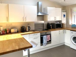 a kitchen with white cabinets and a dishwasher at Greenwood in Manchester