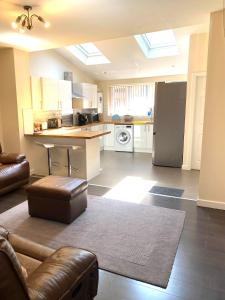 a living room with a kitchen with a refrigerator at Greenwood in Manchester