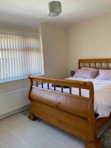 a bedroom with a wooden bed and a window at Greenwood in Manchester