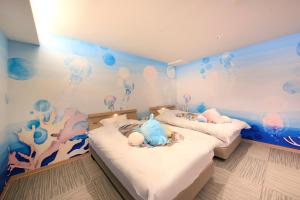 two beds in a room with an aquarium mural at Yuyado Mikannoki in Atami