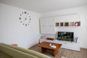 sala de estar con sofá y reloj en la pared en Casa soleggiata sull'altopiano, en Clusone