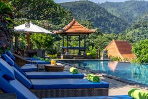 a pool at a resort with mountains in the background at Villa Selonding Batu in Lovina