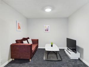 uma sala de estar com um sofá e uma mesa de centro em Luxury Accommodation with TVs in each Room em Macclesfield