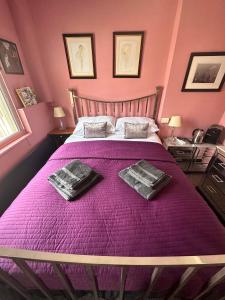 a bedroom with a purple bed with two towels on it at Green Dragon LUDLOW in Ludlow