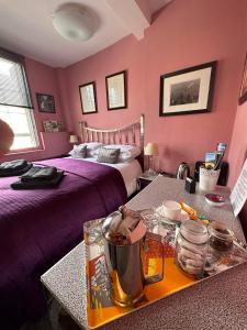 a hotel room with two beds with pink walls at Green Dragon LUDLOW in Ludlow