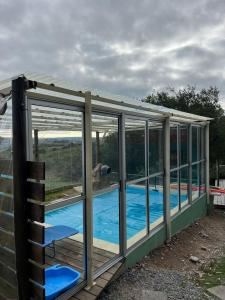 a glass house with a pool in it at Casa CALMA en Villa Serrana in Villa Serrana