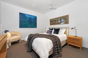 a bedroom with a bed and a desk and a chair at The View by Experience Jervis Bay in Huskisson