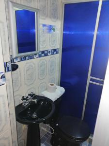 a bathroom with a sink and a blue shower at HOTEL LA 7MA AZUL in Pasto