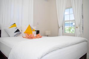 Schlafzimmer mit einem großen weißen Bett und einem Fenster in der Unterkunft Modern & Spacious 2-BDRM/ Gated/Near Ocho Rios in Boscobel