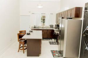 a kitchen with a refrigerator and a table and chairs at Modern & Spacious 2-BDRM/ Gated/Near Ocho Rios in Boscobel