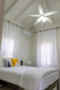 a white bedroom with a ceiling fan and a bed at Modern & Spacious 2-BDRM/ Gated/Near Ocho Rios in Boscobel