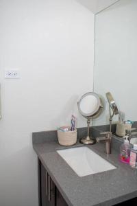 eine Badezimmertheke mit einem Waschbecken und einem Spiegel in der Unterkunft Modern & Spacious 2-BDRM/ Gated/Near Ocho Rios in Boscobel