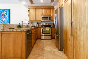 a kitchen with wooden cabinets and stainless steel appliances at Playa Blanca Condo - 9th Floor Ocean Views! in San Carlos