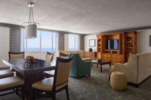 Una sala de estar con una mesa y sillas y un televisor. en Marriott Sanibel Harbour Resort & Spa, en Fort Myers