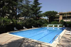 una gran piscina con sillas y un edificio en Residence Parco Salario, en Roma