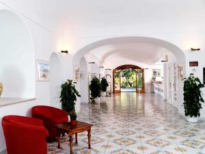 - un salon avec des chaises rouges et une table dans l'établissement Hotel San Lorenzo Thermal Spa, à Ischia