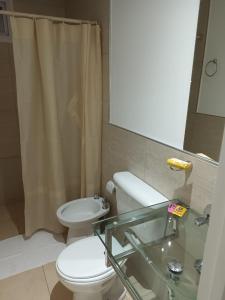 ein Badezimmer mit einem WC, einem Waschbecken und einem Spiegel in der Unterkunft Grace Apartaments in San Juan