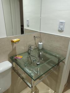 a bathroom with a glass sink and a toilet at Grace Apartaments in San Juan +23 photos