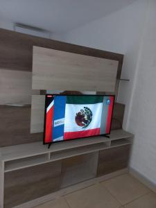 einen Flachbild-TV auf einem Regal in der Unterkunft Grace Apartaments in San Juan