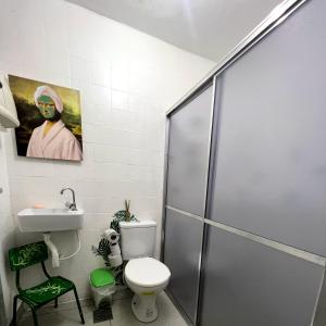 uma casa de banho com um chuveiro, um WC e um lavatório. em Casa Jardim Hostel BH - Santa Efigênia - Paraíso em Belo Horizonte
