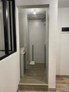 um corredor de uma casa de banho com uma cabina de duche ao nível do chão em Hotel Amatista-Cerca al Aeropuerto em Bogotá