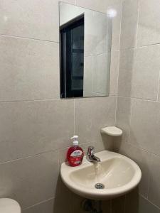 a bathroom with a sink and a mirror at Hotel Amatista-Cerca al Aeropuerto in Bogotá