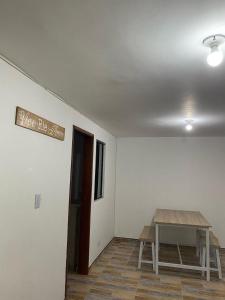 una habitación con una mesa y un cartel en la pared en Hotel Amatista-Cerca al Aeropuerto, en Bogotá