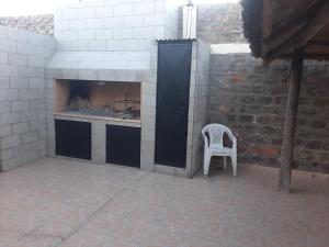 a white chair sitting in front of a fireplace at Chacras Mza in Ciudad Lujan de Cuyo
