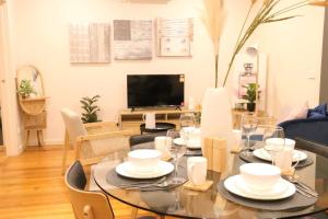 a dining room with a table with chairs and a television at Footscray home just 7km away to Melbourne CBD newly stylist setup in Melbourne