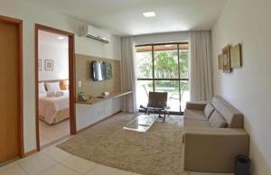 a living room with a couch and a bed at Residencial ILOA in Barra de São Miguel