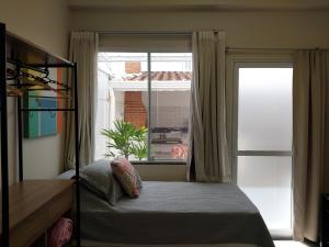 a bedroom with a bed in front of a window at Studio Bena 2 - single bed - próx Shopping Iguatemi in Campinas