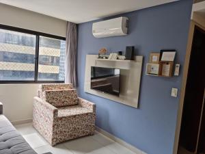 ein blaues Zimmer mit einem Stuhl und einem Fenster in der Unterkunft Excelente apartamento na praia de ponta verde in Maceió